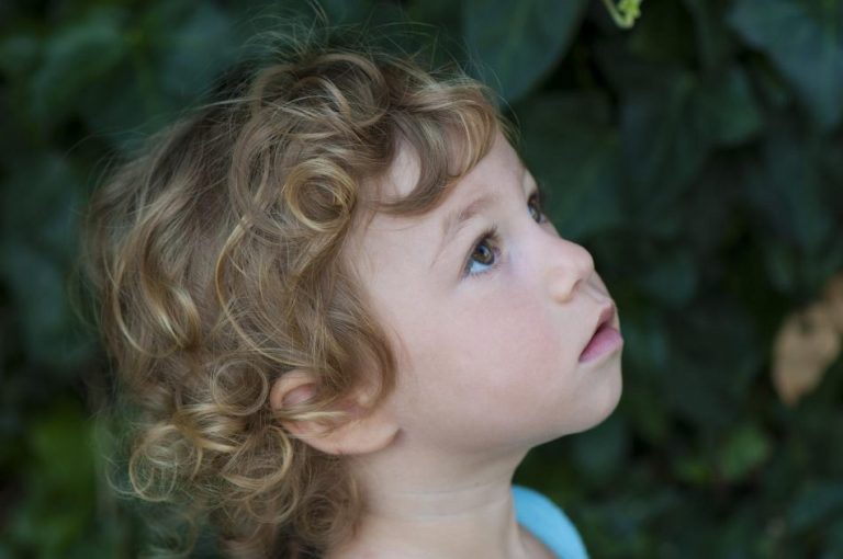 Vrouw met gezonde krullen na gebruik van goede verzorgingsproducten speciaal voor krullend haar
